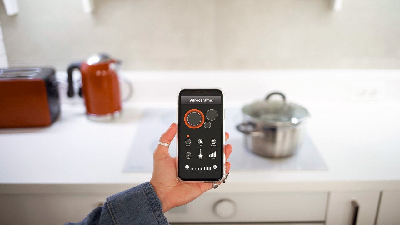 imagem de uma mulher segurando o celular utilizando um aplicativo de automação residencial em seu apartamento