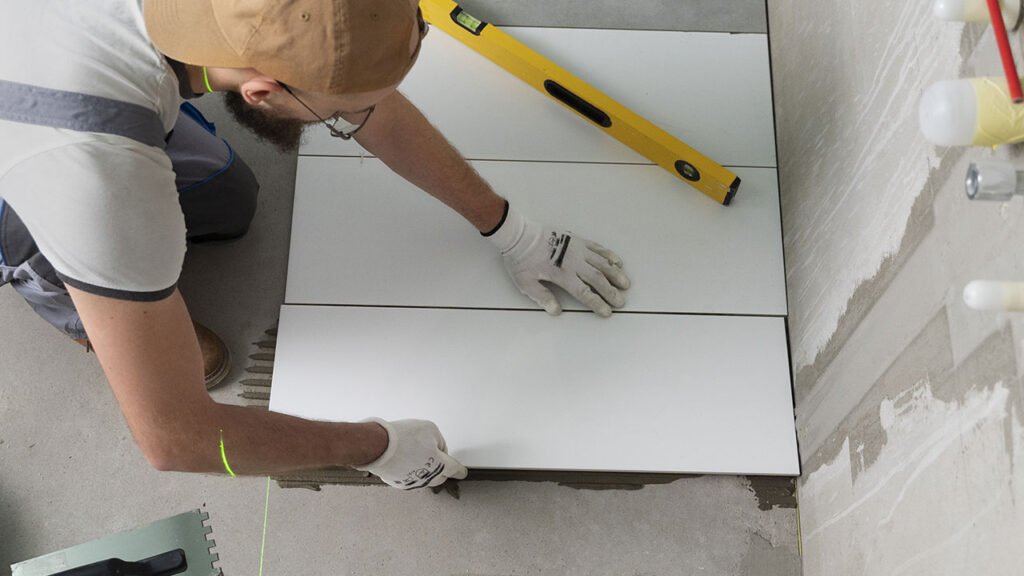 Empreiteiro corta cuidadosamente um piso de porcelanato, destacando a atenção aos detalhes e o acabamento refinado característicos de imóveis de alto padrão.